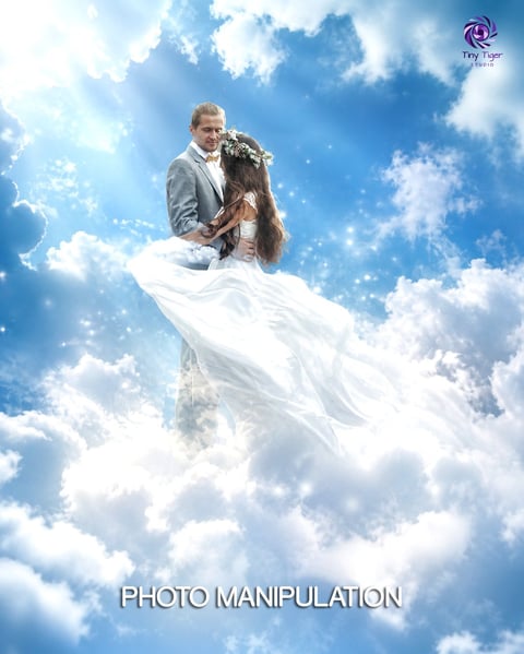 Groom holding bride in white dress floating on clouds in sky, fantasy photo manipulation